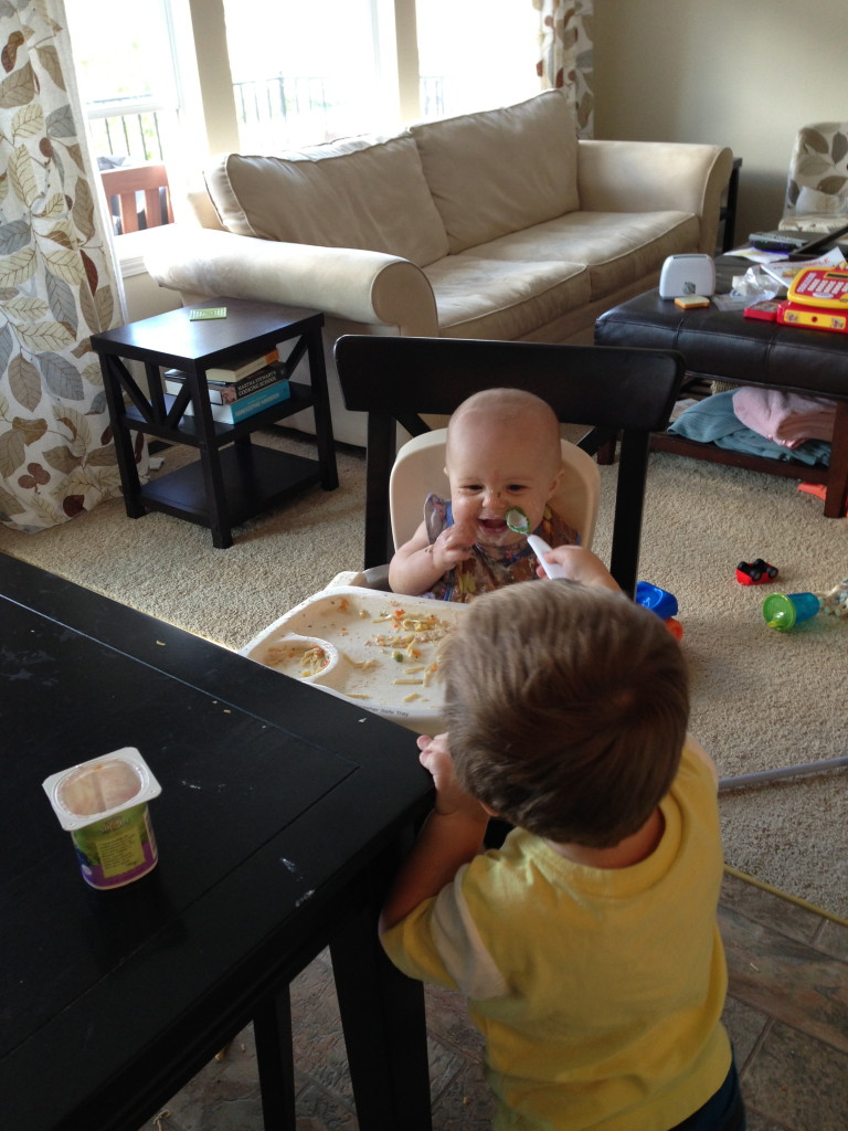 Feeding his sister.