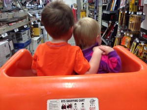Sharing a car cart with his sister.