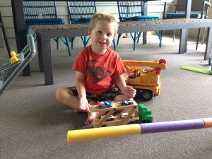 Playing with his car carrier truck.